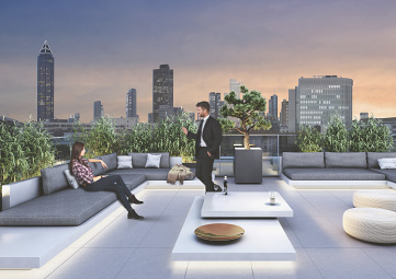 Mann und Frau treffen sich auf der studiomuc Dachterrasse mit Frankfurter Skyline im Hintergrund